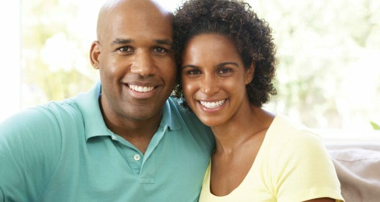 Young, smiling couple on sofa